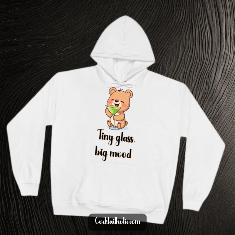 Funny bear hoodie depicting a small bear character holding and sipping a miniature martini glass, embodying cozy contentment and humor.